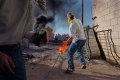 Dei manifestanti lanciano motolov durante gli scontri tra le truppe israeliane e la popolazione locale. Territori occupati, Cisgiordania, 2000,  James Nachtwey